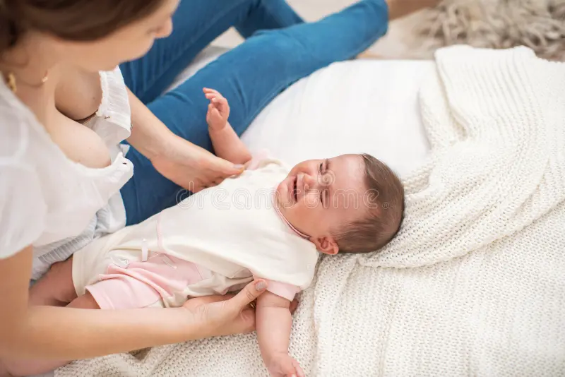 Madre sosteniendo a su bebé en brazos mientras practica una respiración consciente para calmar el llanto